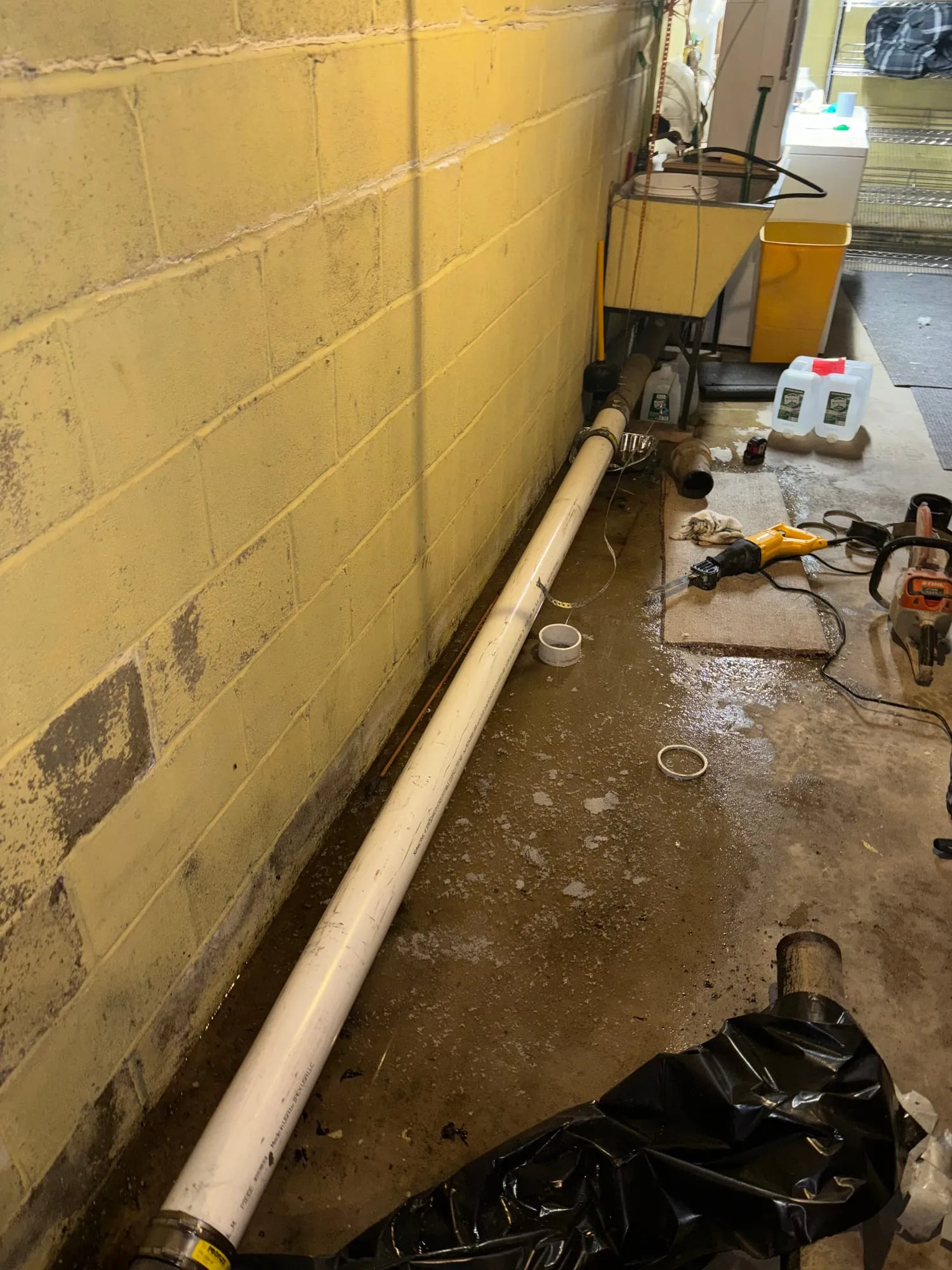 A new PVC line run along a basement wall