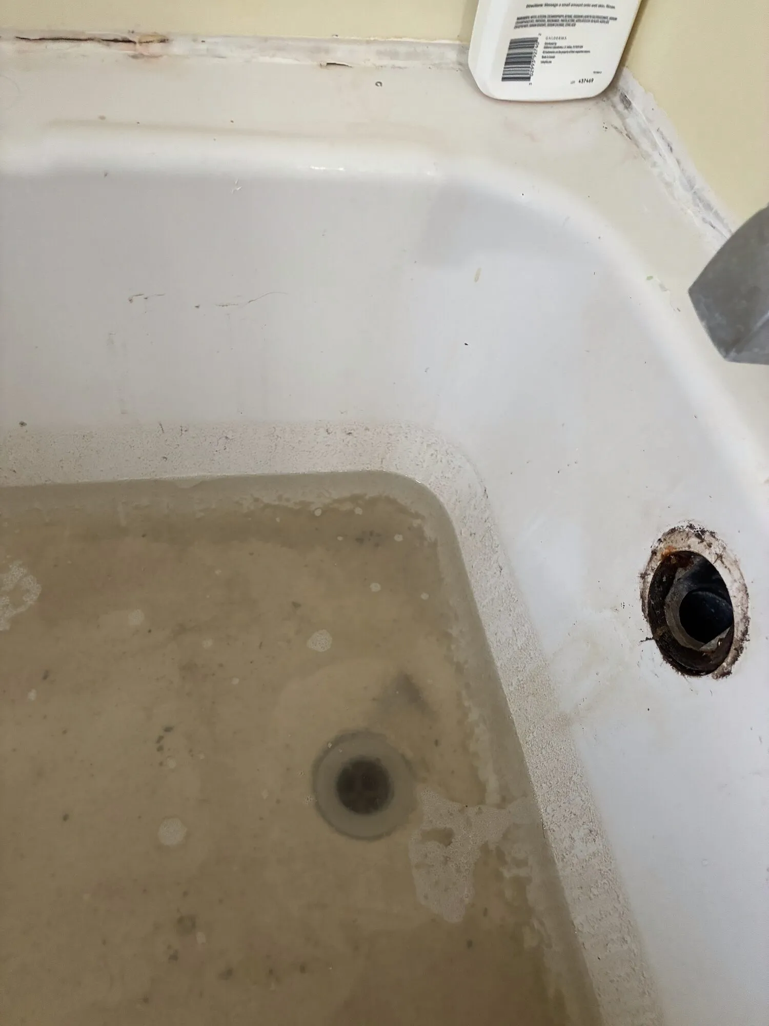 A tub holding standing water before the drain was cleared