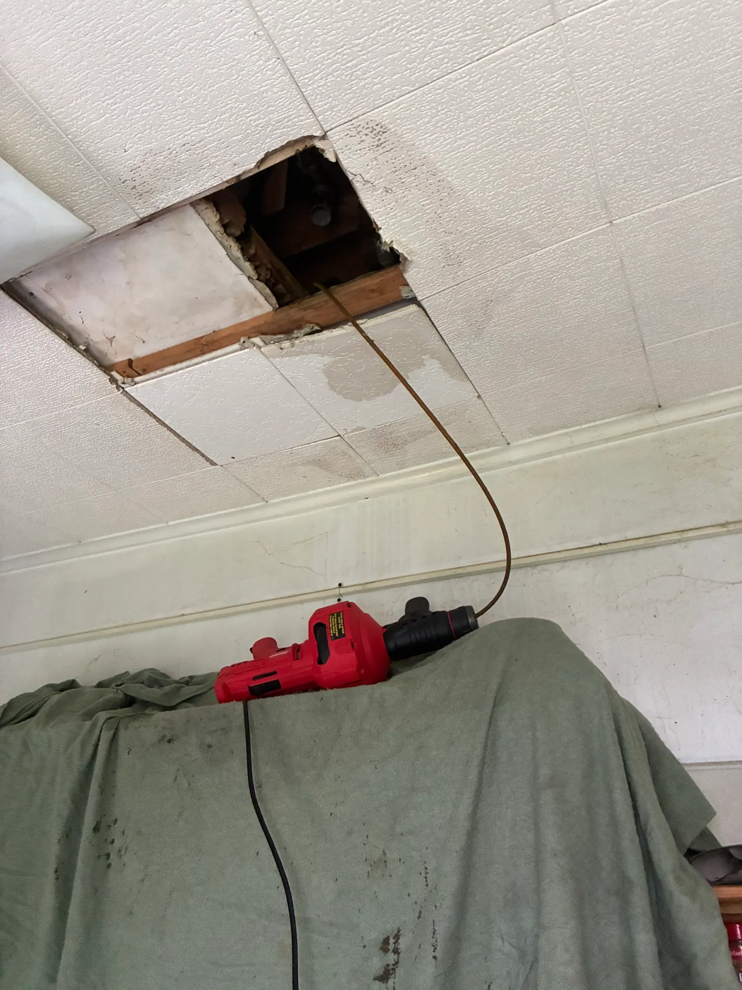Feeding a drain cable up through a ceiling access on a commercial job