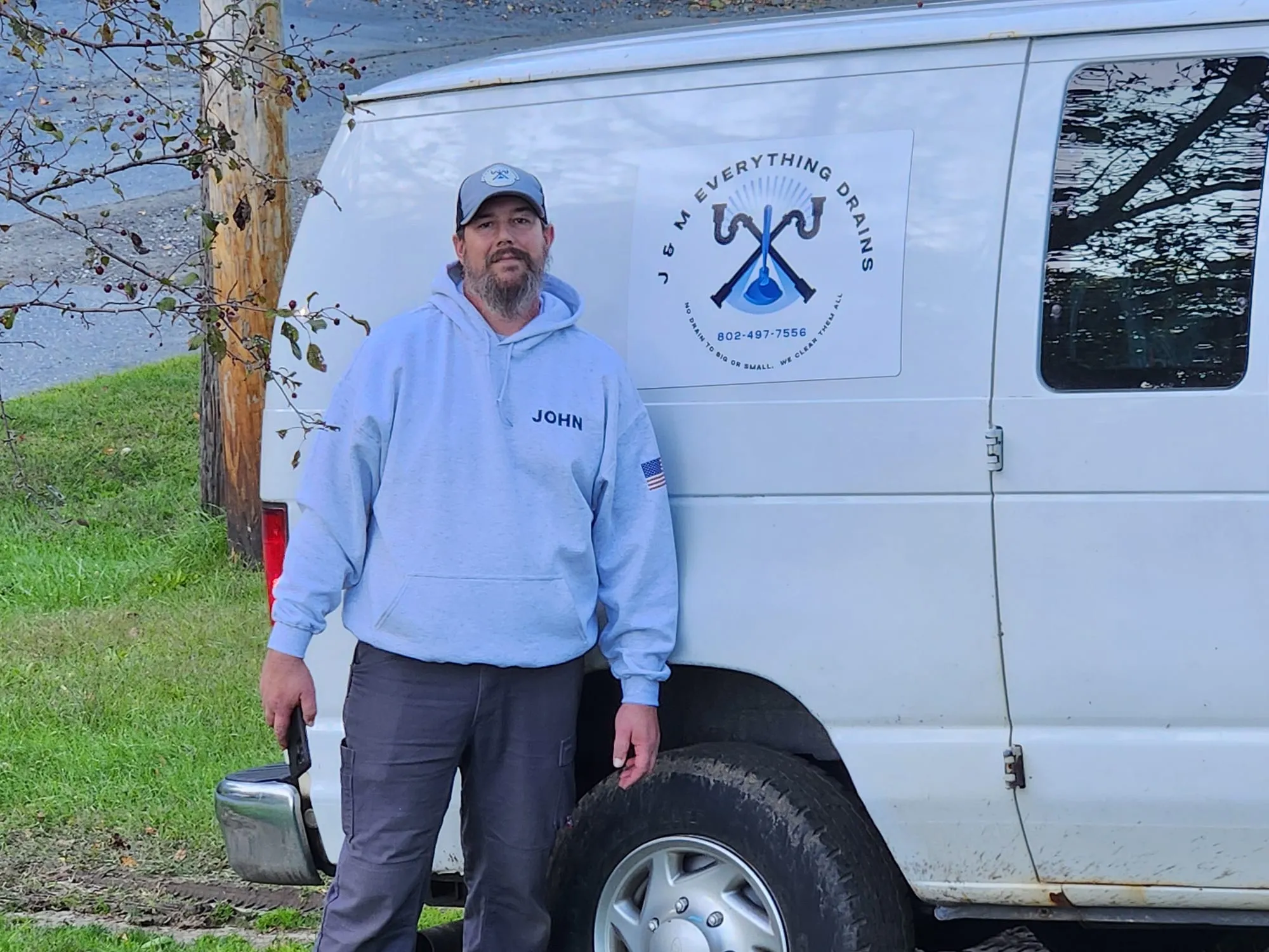 John Haire, owner of J & M Everything Drains, beside his service van