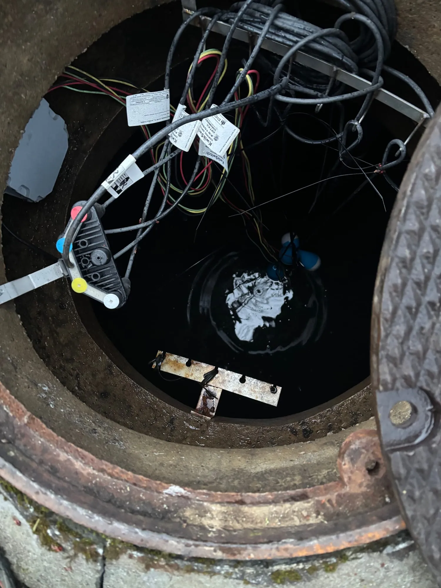 Looking down into a pump station wet well at the floats and cables